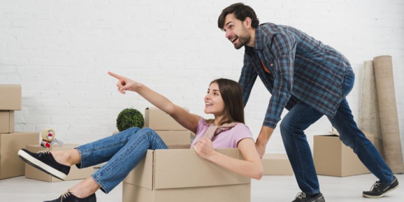 happy-couple-is-having-fun-with-cardboard-boxes-new-house_23-2148095521